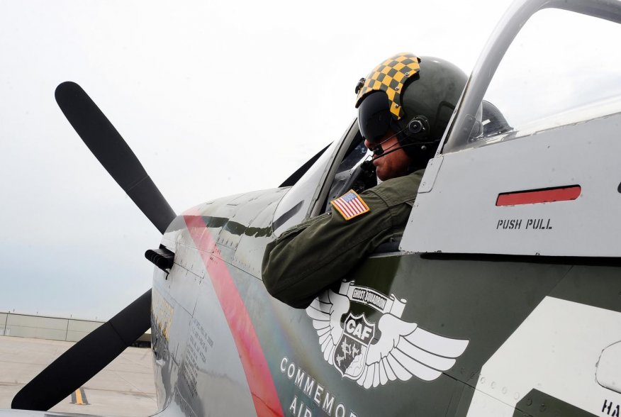 Larry Lumpkin, pilot of the P-51 Mustang, dons his helmet and flight suit for a media photo shoot at the Council Bluffs Municipal Airport, Iowa, on June 27. (U.S. Air Force photo by Josh Plueger)