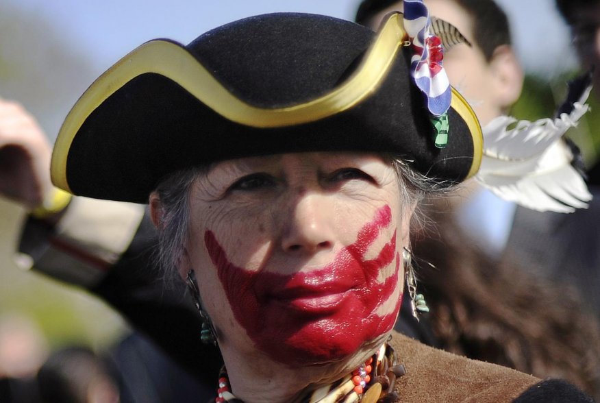 Tea party supporter Susan Clark of California, dressed in colonial garb and face paint, protests against the Obama healthcare legislation as the law's supporters and detractors rally on the sidewalk in front of the Supreme Court, during the third and fina