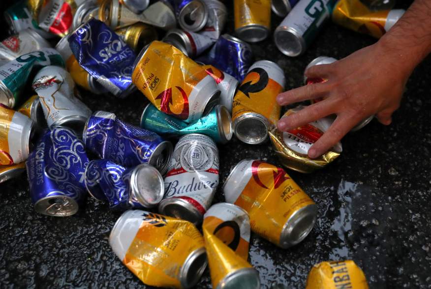 A recycled waste collector picks up beer cans during carnival block party “Unidos do Swing” in Sao Paulo, Brazil, February 24, 2020. REUTERS/Amanda Perobelli