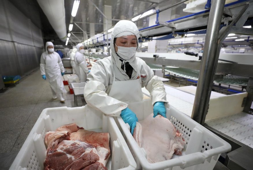 Employees work at a pig slaughtering and pork processing plant in Huaian, Jiangsu province, China April 9, 2020. Picture taken April 9, 2020. China Daily via REUTERS