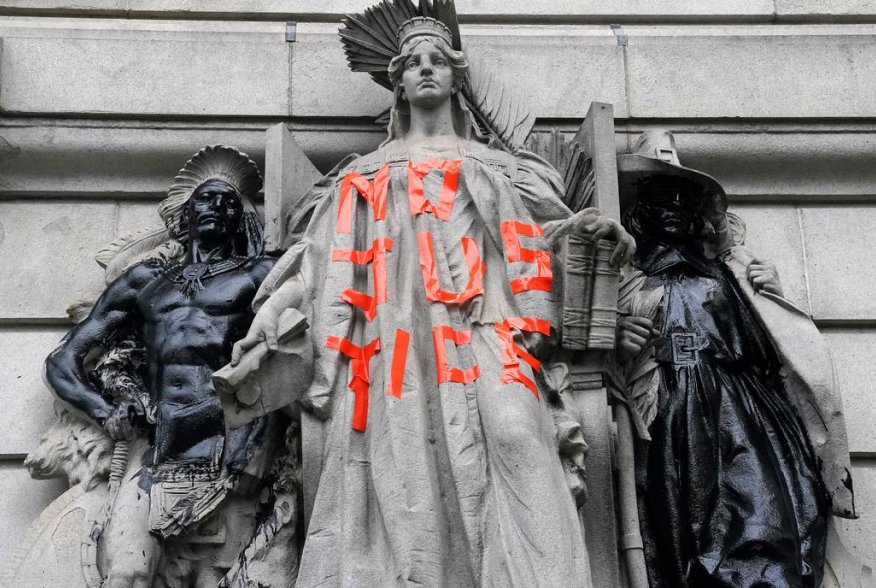 A defaced statue is pictured across from a protest to defund the police in a place they are calling the "City Hall Autonomous Zone" in support of "Black Lives Matter" in the Manhattan borough of New York City, New York, U.S., June 30, 2020. REUTERS/Carlo 