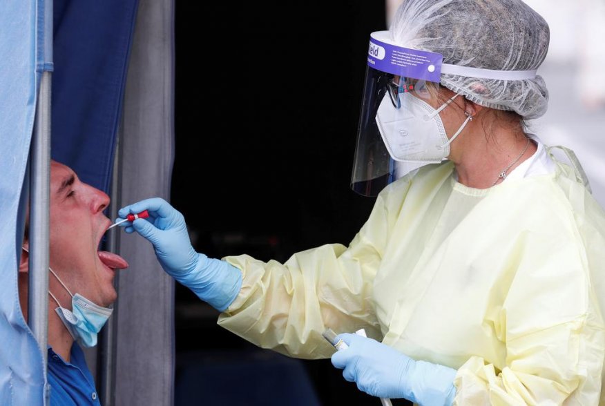 A healthcare worker takes a swab sample from a man at a coronavirus disease (COVID-19) test centre at Rome's San Giovanni hospital in Rome, Italy, August 18, 2020. REUTERS/Remo Casilli