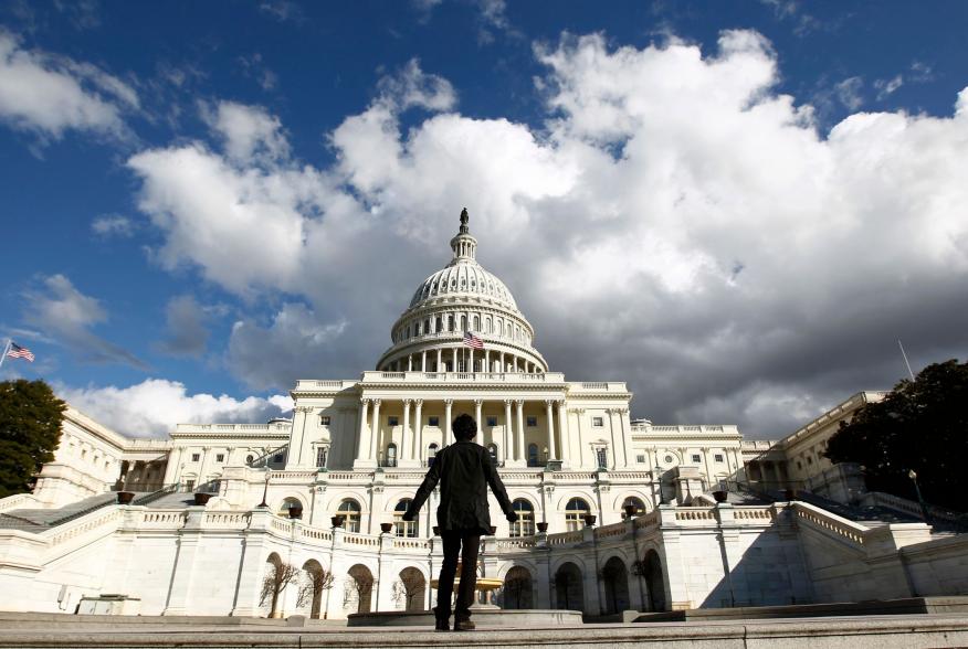 A tourist gazes up towards the dome of the U.S. Capitol in Washington January 25, 2010. On Wednesday, U.S. President Barack Obama will deliver his first State of the Union speech in the House Chamber of the Capitol. REUTERS/Kevin Lamarque (UNITED STATES -