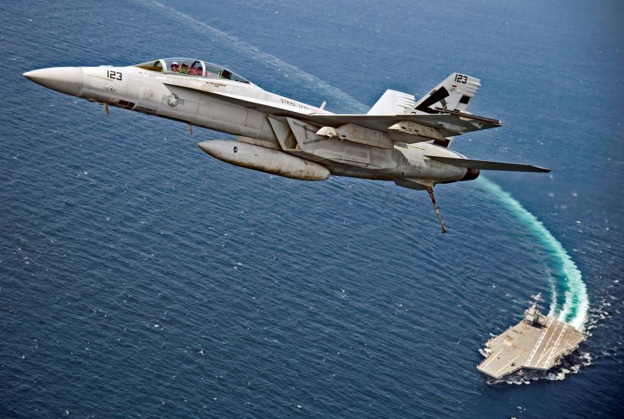 An F/A-18F Super Hornet jet flies over the USS Gerald R. Ford as the U.S. Navy aircraft carrier tests its EMALS magnetic launching system, which replaces the steam catapult, and new AAG arrested landing system in the Atlantic Ocean July 28, 2017. Picture 