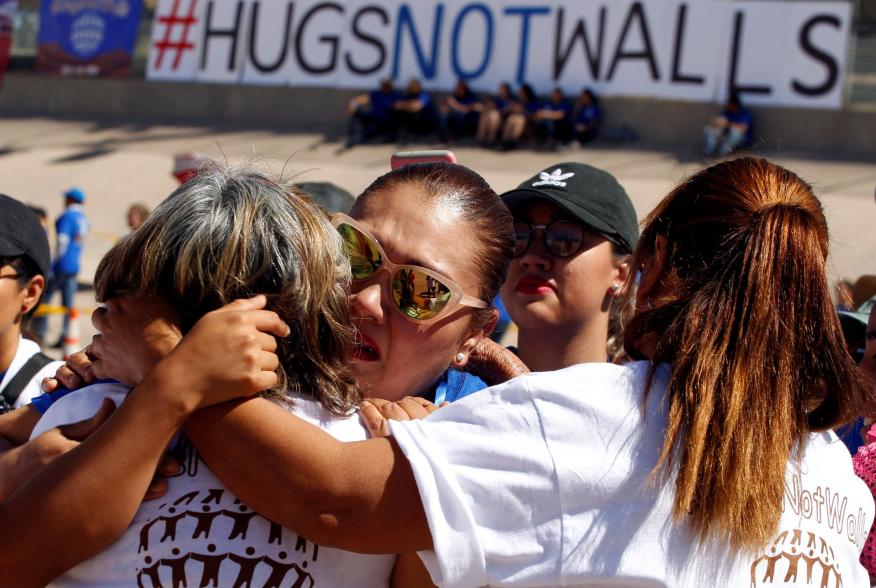 Mexicans (white shirts), who live in Mexico, hug relatives (blue shirts), who live in the U.S., during the Hugs Not Walls event on the border between Ciudad Juarez, Mexico and El Paso, U.S., May 12, 2018. REUTERS/Jose Luis Gonzalez