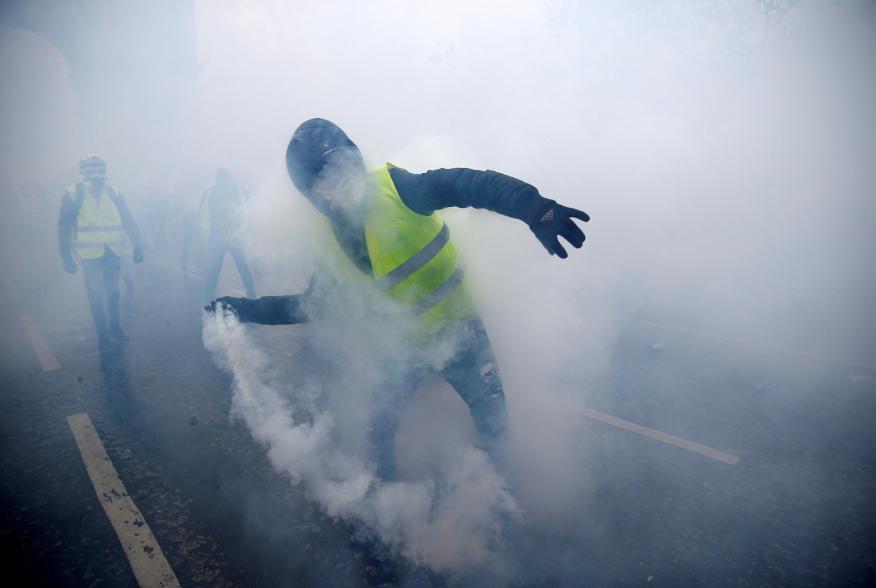 FILE PHOTO: Tear gas fills the air as a protester wearing a yellow vest, a symbol of a French drivers' protest against higher diesel taxes, demonstrates near the Place de l'Etoile in Paris, France, December 1, 2018. REUTERS/Stephane Mahe/File Photo