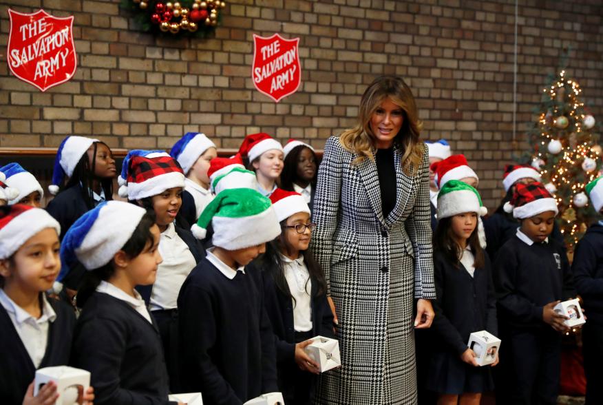 U.S. first lady Melania Trump poses with a children choir after joining local school students and U.S. Marines stationed at the U.S. Embassy, wrapping holiday presents to be donated to the Salvation Army, at the Salvation Army Clapton Center