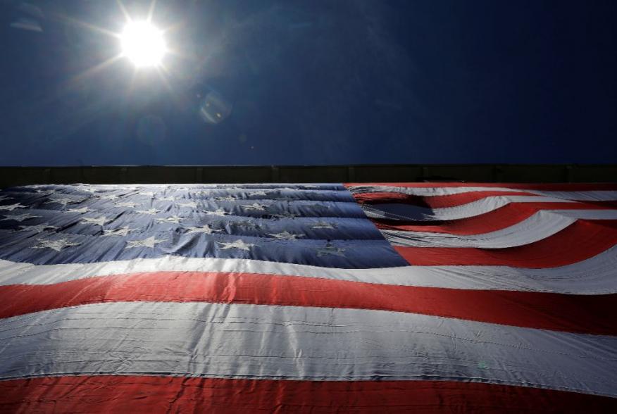 As 95-by-50-foot American flag is unfurled on the side of an apartment complex, a replica of the "The Great Flag" that was spun, woven, dyed, constructed and displayed on the same building by Amoskeag Manufacturing Company in 1914, in Manchester, New Hamp