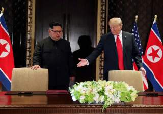 FILE PHOTO: U.S. President Donald Trump and North Korea's leader Kim Jong Un (L) arrive to sign a document to acknowledge the progress of the talks and pledge to keep momentum going, after their summit at the Capella Hotel on Sentosa island in Singapore, 