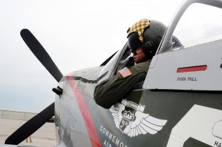 Larry Lumpkin, pilot of the P-51 Mustang, dons his helmet and flight suit for a media photo shoot at the Council Bluffs Municipal Airport, Iowa, on June 27. (U.S. Air Force photo by Josh Plueger)