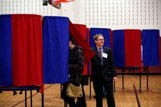 Election official Bill McClure assists voters at a polling place in Portsmouth, New Hampshire, U.S., November 6, 2018. REUTERS/Elizabeth Frantz