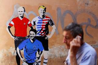 A man walks past a mural signed by 