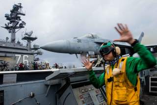 PHILIPPINE SEA (July 4, 2018) Aviation Boatswain's Mate (Equipment) 1st Class Clayton Hudson, from Fairfield, Calif., signals for the launch of an F/A-18E Super Hornet assigned to Strike Fighter Squadron (VFA) 115 on the flight deck of the Navy's forward-