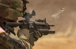 A shell casing flies out with a trail of smoke as U.S. Army Pfc. Michael Freise fires an M-4 rifle during a reflex firing exercise at the Rodriguez Live Fire Complex, Republic of Korea, on March 23, 2005.