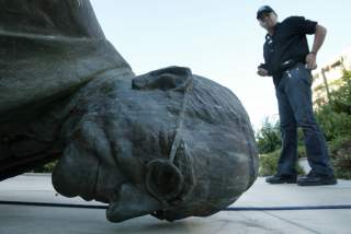 A man walks past the statue of U.S. President Harry S. Truman in Athens, July 25, 2006, which was pulled down by Greek leftists in a move harking back to the U.S. invasion of Iraq as part of an anti-war demonstration against the Israeli bombing of Lebanon