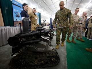 A soldier looks at a MAARS (Modular Advanced Armed Robotic System) robot at the Marine West Military Expo at Camp Pendleton, California February 1, 2012. The expo is one of the year's largest annual display of new military equipment. REUTERS/Mike Blake (U