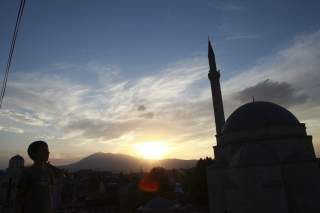 Image: A boy looks at the sky near an orthodox church and a mosque in Prizren, southwest from capital Pristina August 20, 2014. REUTERS/Hazir Reka 