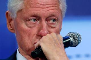 Former U.S. President Bill Clinton listens to speakers during the opening plenary session labeled 