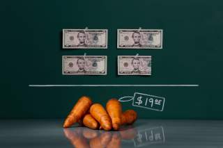 A kilogram (2.2 lbs) of raw carrots as photographed in a studio with an illustrative price tag of $19.05 (US dollars), equivalent to the Bs. 120 (bolivars) that it costs on average to purchase in Caracas at the official exchange rate of 6.3 bolivars per d