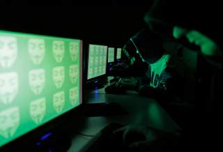 People pose in front of a display showing the word 'cyber' in binary code, in this picture illustration taken in Zenica December 27, 2014. Picture taken December 27, 2014. REUTERS/Dado Ruvic (BOSNIA AND HERZEGOVINA)