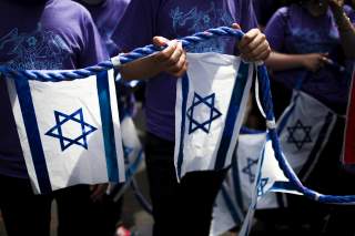 People hold a rope with Israeli national flags attached to it during the 51st annual Israel parade in Manhattan, New York May 31, 2015. REUTERS/Eduardo Munoz 