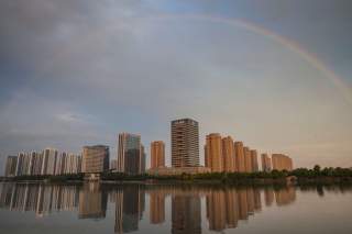 A rainbow appears over buildings reflected in water early morning in Shaoxing, China June 17, 2017. Picture taken June 17, 2017. REUTERS/Stringer 