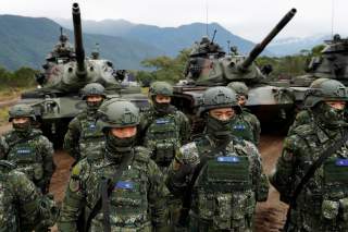 Taiwanese soldiers stand in front of a M60A3 tank during a military drill in Hualien, eastern Taiwan, January 30, 2018. REUTERS/Tyrone Siu