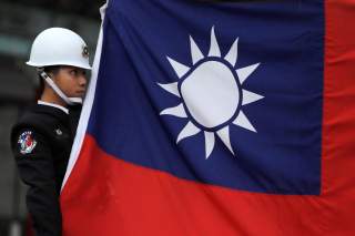 A military honour guard holds a Taiwanese national flag as he attending flag-raising ceremony at Chiang Kai-shek Memorial Hall, in Taipei, Taiwan March 16, 2018. REUTERS/Tyrone Siu