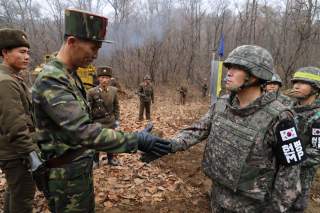 A South Korean military officer (R) and a North Korean military officer shake hands during an operation to reconnect a road across the Military Demarcation Line inside the Demilitarised Zone (DMZ) separating the two Koreas November 22, 2018. Picture taken