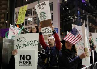 People protest outside before former Starbucks CEO Howard Schultz speaks during his book tour in Seattle, Washington, U.S., January 31, 2019. REUTERS/Jason Redmond