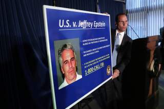 An employee of the Southern District of New York hangs a sign containing a photograph of Jeffrey Epstein, charged of sex trafficking of minors and conspiracy to commit sex trafficking of minors, in New York, U.S., July 8, 2019. REUTERS/Shannon Stapleton