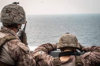 Marines onboard the amphibious transport dock ship USS John P. Murtha (LPD 26) watch nearby Iranian fast inland attack craft, as it transits the Strait of Hormuz, off Oman, in this undated handout picture released by U.S. Navy on August 12, 2019.