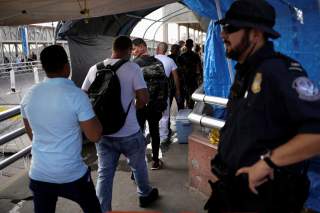 A U.S. Customs and Border Protection (CBP) agent looks at Cuban migrants entering into the United States to claim asylum, at the Santa Fe border crossing bridge in Ciudad Juarez, Mexico September 9, 2019. REUTERS/Jose Luis Gonzalez