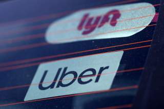 FILE PHOTO: Uber and Lyft signs are seen on a car in Redondo Beach, California, U.S., March 25, 2019. REUTERS/Lucy Nicholson/File Photo