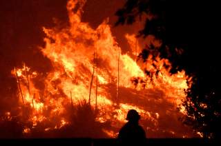 Firefighters battle a wind-driven wildfire called the Saddle Ridge fire in the early morning hours Friday in Porter Ranch, California, U.S., October 11, 2019. REUTERS/Gene Blevins