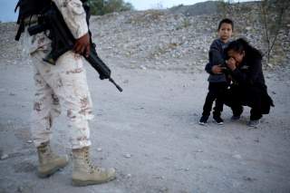 Guatemalan migrant Ledy Perez embraces her son Anthony while praying to ask a member of the Mexican National Guard to let them cross into the United States, as seen from Ciudad Juarez, Mexico, July 22, 2019. Reuters Photographer Jose Luis Gonzalez