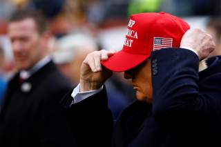 U.S. President Donald Trump puts on a Keep America Great hat during the annual Army-Navy collegiate football game at Lincoln Financial Field in Philadelphia, PA, U.S., December 14, 2019. REUTERS/Tom Brenner