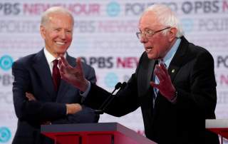 Former Vice President Joe Biden laughs as Senator Bernie Sanders speaks at the 2020 Democratic campaign debate at Loyola Marymount University in Los Angeles, California, U.S., December 19, 2019. REUTERS/Mike Blake