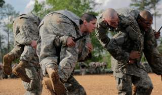 Then U.S. Army First Lieutenant Kirsten Griest (C) and fellow soldiers participate in combatives training during the Ranger Course on Fort Benning, Georgia, in this handout photograph taken on April 20, 2015 and obtained on August 20, 2015. When Griest an