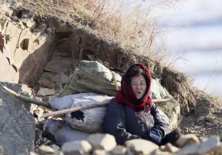 A North Korean woman rests on on the banks of Yalu River, in Sakchu county, North Korea, January 7, 2016. REUTERS/Jacky Chen