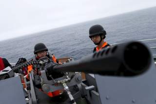 Taiwanese Coast Guard Administration guard demonstrate a machine gun on the docks of the 3000-ton 