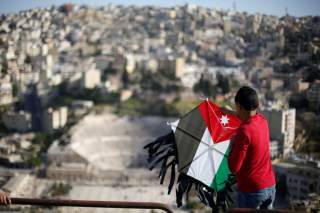 A boy flies his kite decorated with the Jordanian national flag during an event celebrating spring at the Citadel in Amman, Jordan, April 15, 2016. REUTERS/Muhammad Hamed