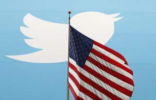 The Twitter Inc. logo is shown with the U.S. flag during the company's IPO on the floor of the New York Stock Exchange in New York, November 7, 2013. REUTERS/Lucas Jackson/File Photo