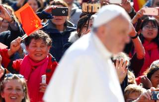 A Chinese pilgrim waves a flag, as Pope Francis arrives to lead his Wednesday general audience, in Saint Peter's Square, at the Vatican March 15, 2017. REUTERS/Tony Gentile