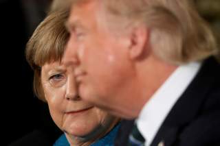 Germany's Chancellor Angela Merkel (L) gives U.S. President Donald Trump a look after he suggested they might have something in common, as he answered a question about his accusation that he had been wiretapped by former President Barack Obama, during the