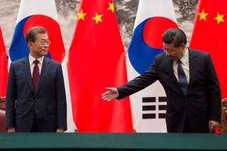 Chinese President Xi Jinping (R) gestures towards South Korean President Moon Jae-In (L) during a signing ceremony at the Great Hall of the People in Beijing, China December 14, 2017. REUTERS/Nicolas Asfouri/Pool