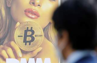 A man stands near an advertisement of a cryptocurrency exchange in Tokyo, Japan March 30, 2018. Picture taken March 30, 2018. REUTERS/Toru Hanai