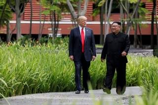 U.S. President Donald Trump and North Korea's leader Kim Jong Un walk together before their working lunch during their summit at the Capella Hotel on the resort island of Sentosa, Singapore June 12, 2018. Picture taken June 12, 2018. REUTERS/Jonathan Erns