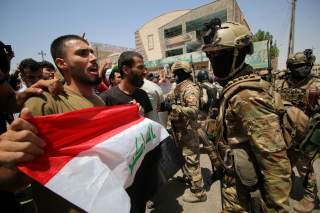 Iraqi security forces stand guard as demonstrators protest in front of Basra provincial council building, demanding jobs and better state services, in Basra, Iraq July 31, 2018. REUTERS/Essam al-Sudani