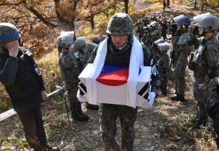 A South Korean soldier carries a casket containing a piece of bone believed to be the remains of an unidentified South Korean soldier killed in the Korean War in the Demilitarized Zone (DMZ) dividing the two Koreas in Cheorwon, South Korea October 25, 201